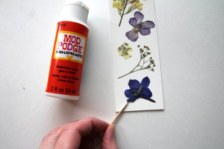 gluing flowers down with Mod Podge