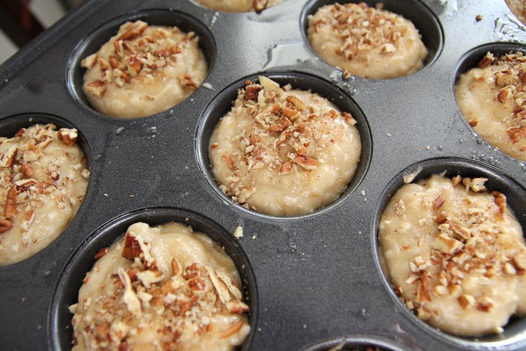 muffins sprinkled with nuts and raw sugar and ready to bake