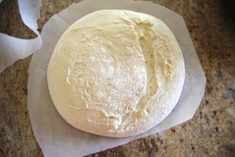 turn dough out onto parchment paper, trim parchment, and score with lame