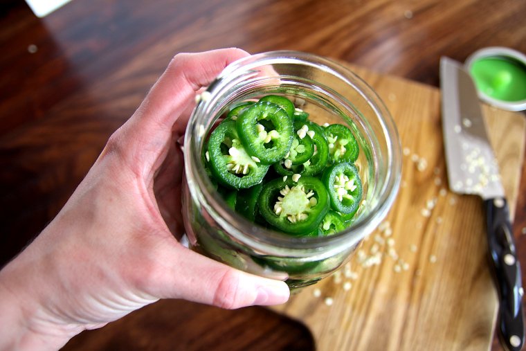 press sliced jalapenos into a 32-ounce jar up to the shoulder