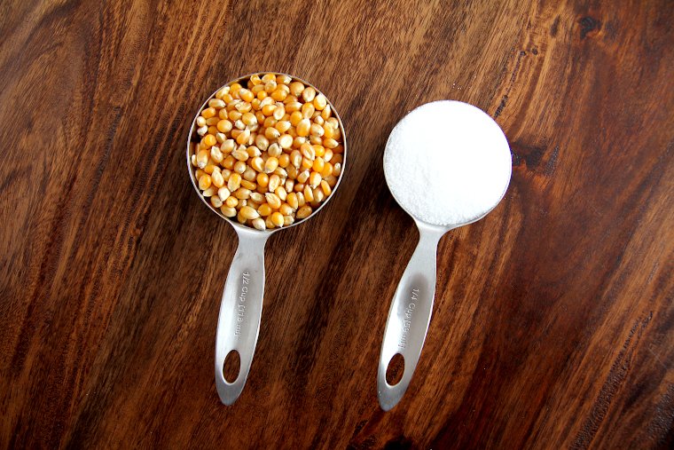 Popcorn kernels and sugar in measuring cups