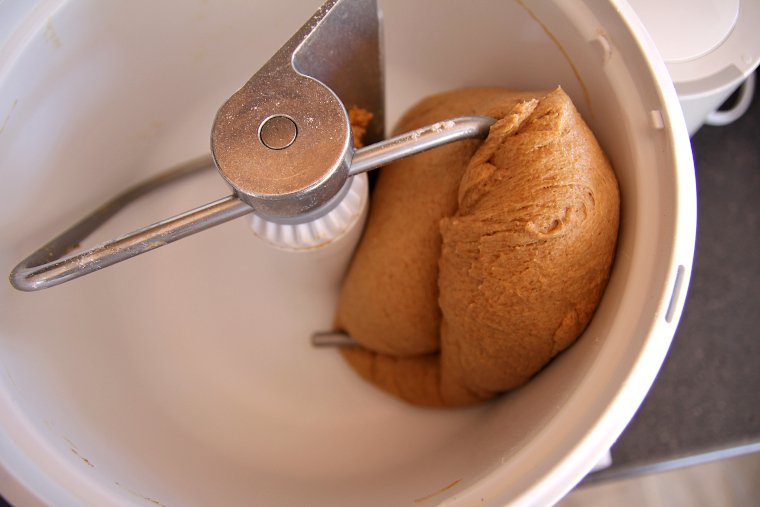 brown dough being kneaded in a Bosch mixer
