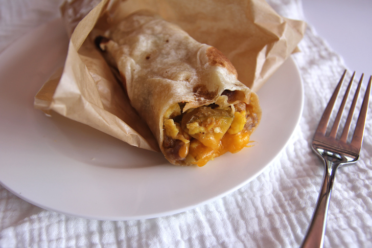homemade green chile breakfast burrito unwrapped on a plate