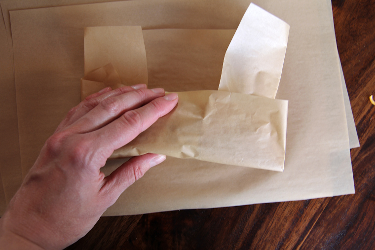 rolling up the parchment paper from the bottom
