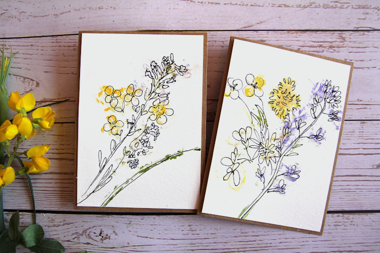 two hammered flower greeting cards on a table next to yellow wildflowers