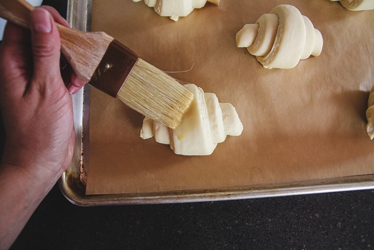 brushing croissants with egg wash