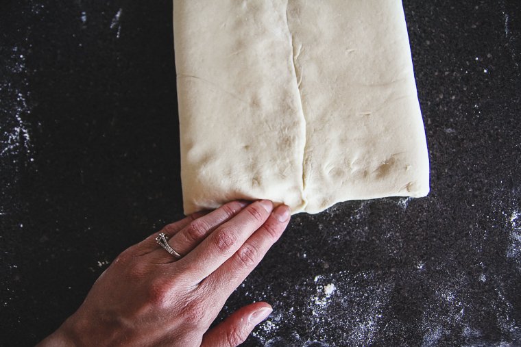 pinching the edges to seal the dough over the butter