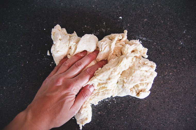 beginning to knead dough on countertop