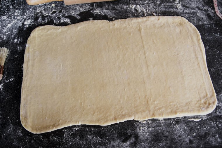 rolling sourdough danish dough to a rectangle in preparation for the second fold