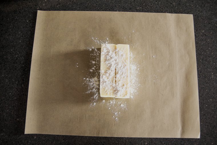butter sprinkled with flour on parchment paper