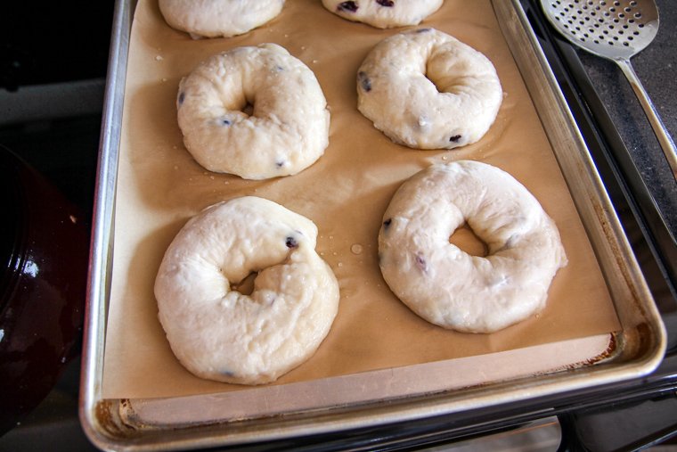 bagels shown back on the baking sheet after boiling