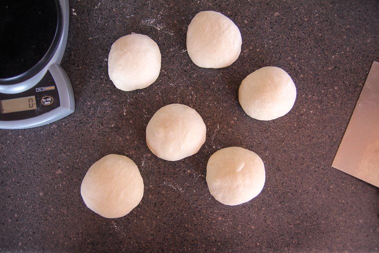 six portions of dough after they have been formed into nice smooth balls