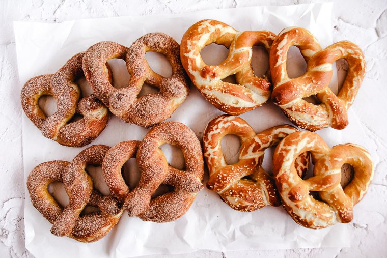 8 sourdough soft pretzels arranged on a piece of white parchment paper