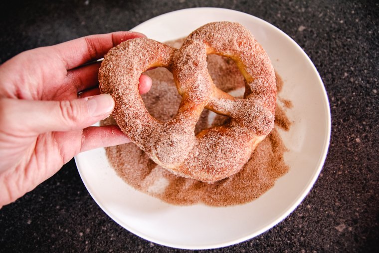 coating the pretzel in a cinnamon sugar mixture