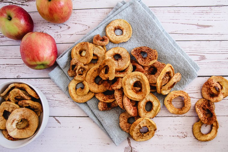 a pile of dehydrated apple rings on a napkin on a white table