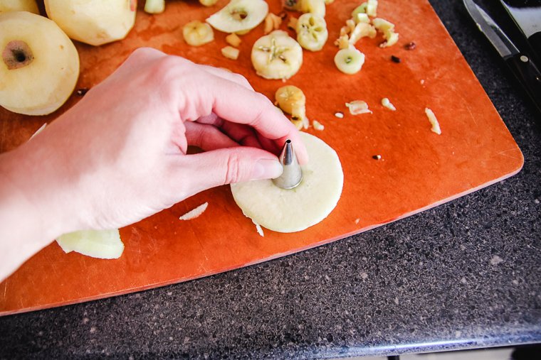 punching out the core of an apple slice with the bottom of a piping tip