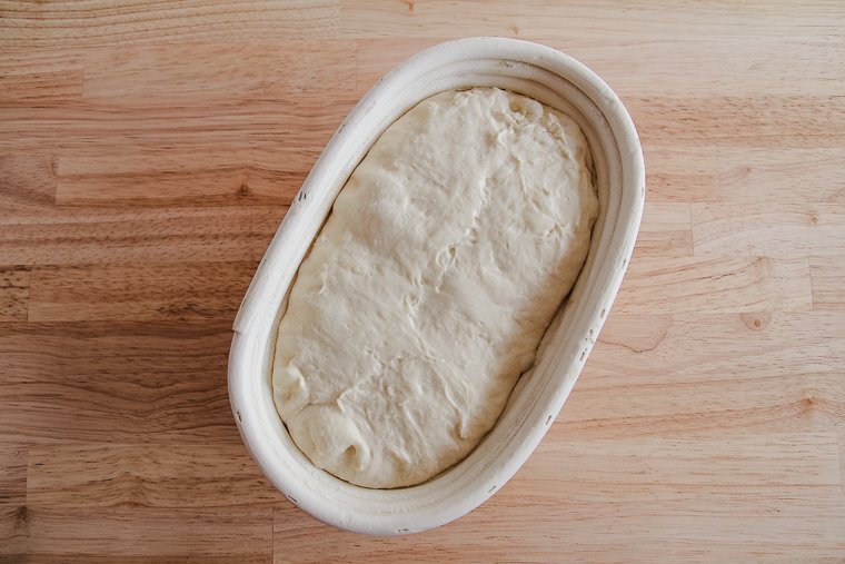 proofed sourdough dough in an oval-shaped banneton