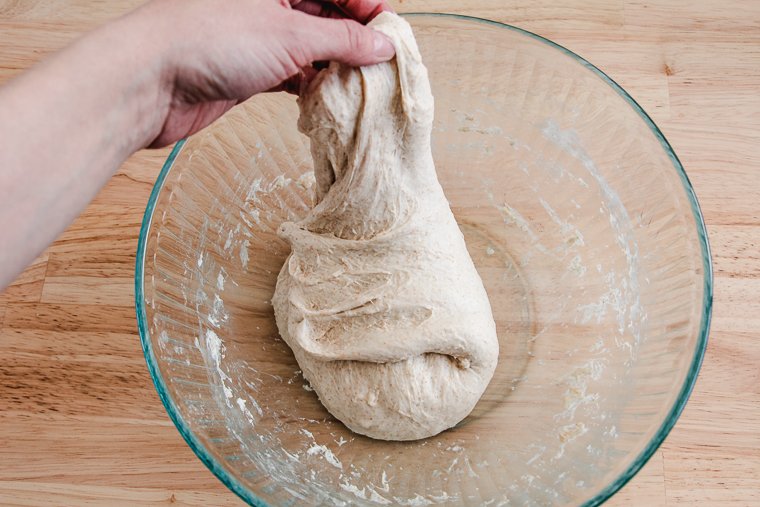 stretching dough in a bowl
