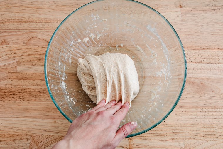 folding dough in a large mixing bowl