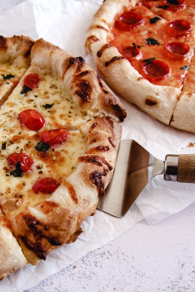 serving a slice of sourdough pizza