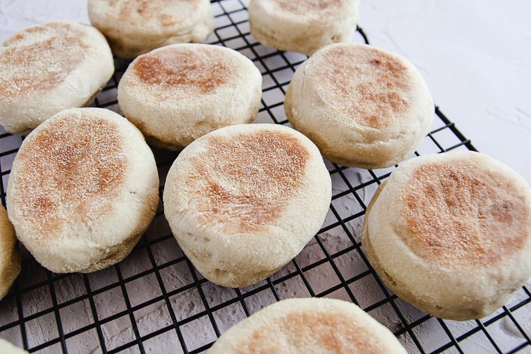 sourdough english muffins cooling on a rack