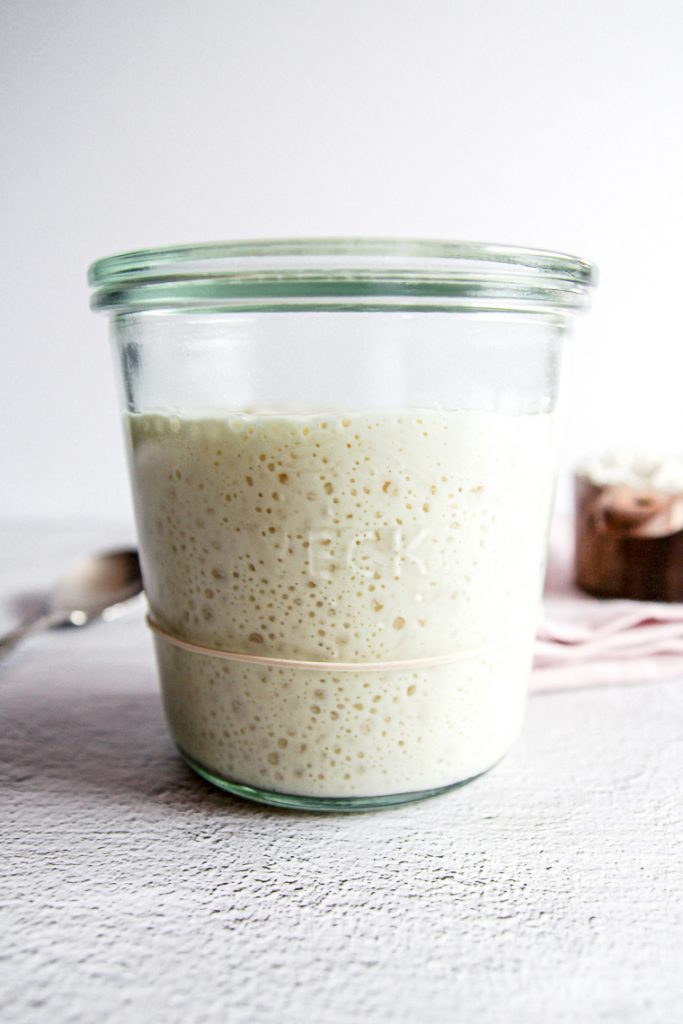 two pictures showing the differences between a whole wheat starter and a white flour starter