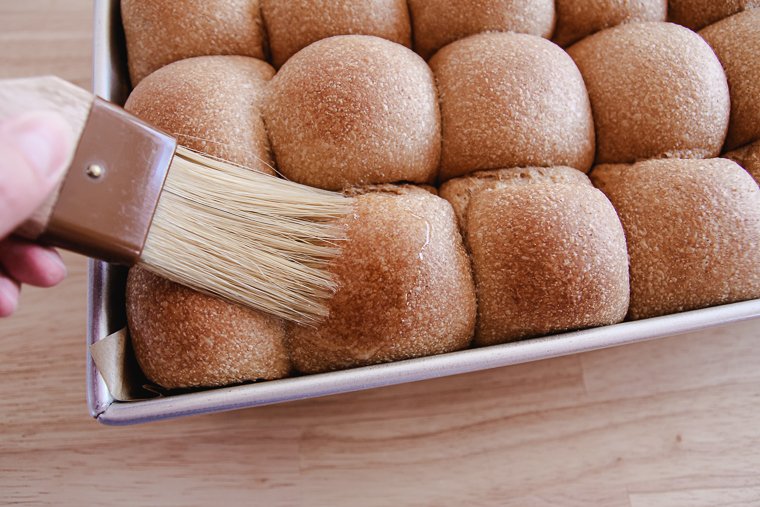 brushing dinner rolls with butter