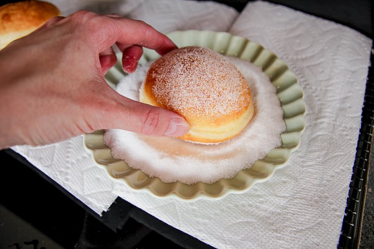 dipping the warm donut in sugar