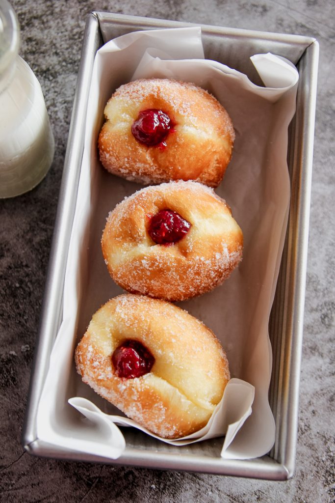 a pan of fried donuts filled with jam