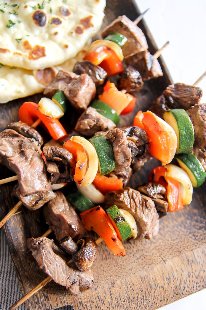 serving naan with grilled steak kabobs