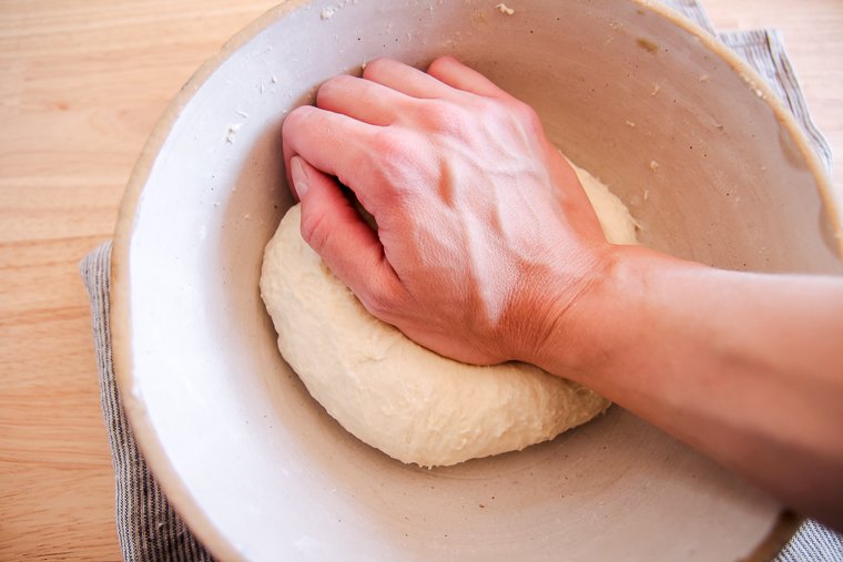 kneading the dough in the bowl