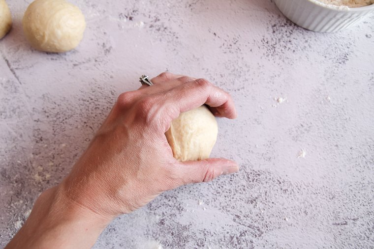 scooting the ball against the countertop to smooth and tighten it