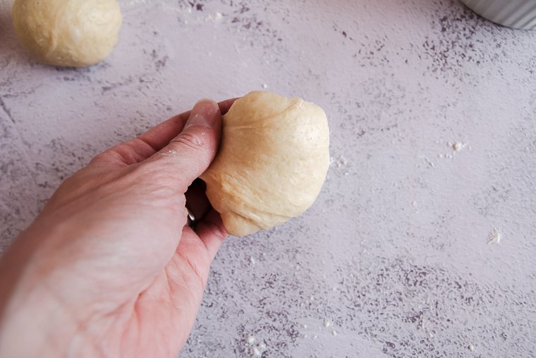 beginning to form the piece of dough into a ball