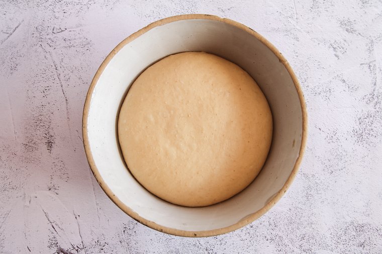 risen sourdough hamburger buns dough in a bowl at the end of bulk fermentation