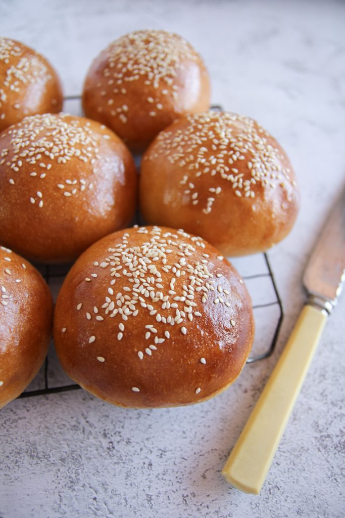 a close up shot of sourdough hamburger buns with sesame seeds