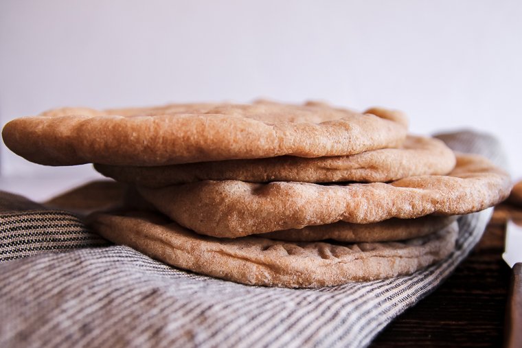 a side view of a stack of whole wheat sourdough pita bread