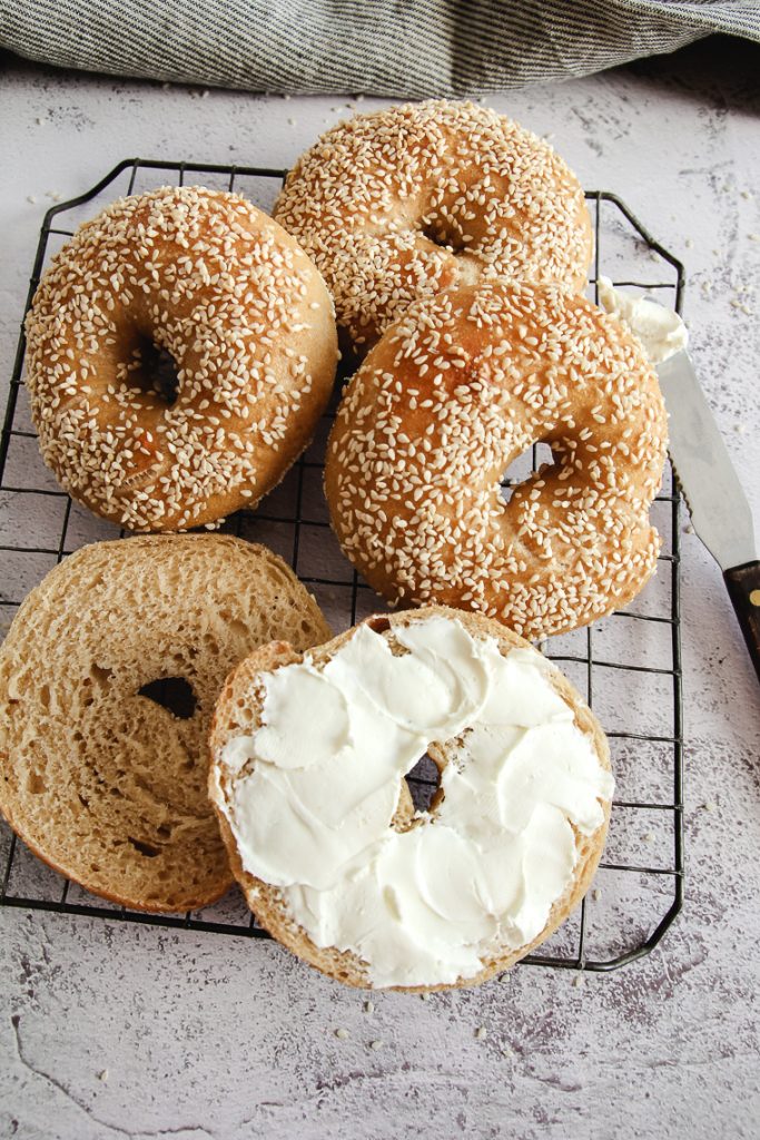 sourdough bagel sliced and spread with cream cheese