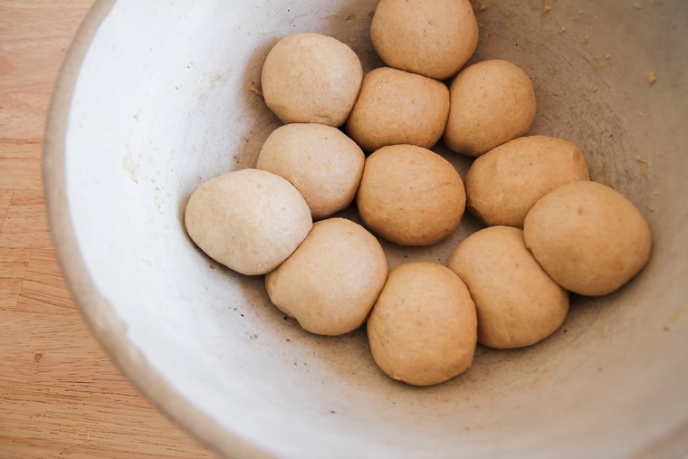 placing the dough balls back into the bowl to let them rest for 30 more minutes