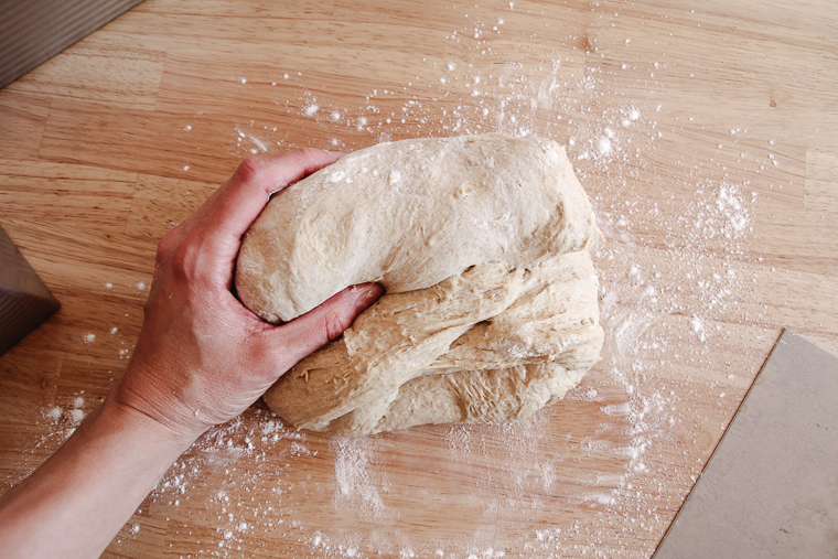 rolling the dough from the top down to form a cylinder