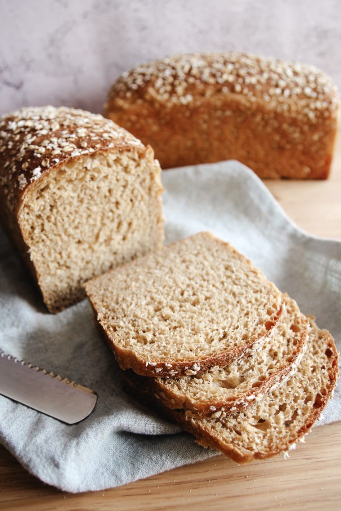 slices of maple oat sourdough bread next to the loaf