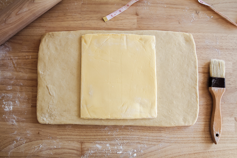 placing the butter block on the rolled out sourdough pastry dough