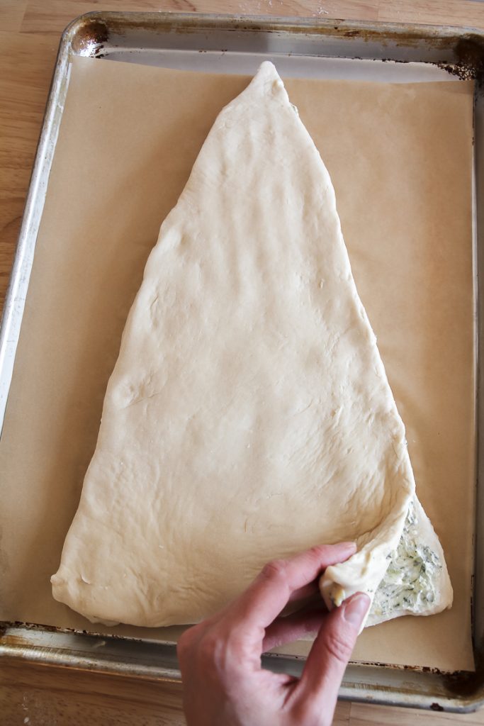 adding the second layer of dough on top over the garlic sourdough filling