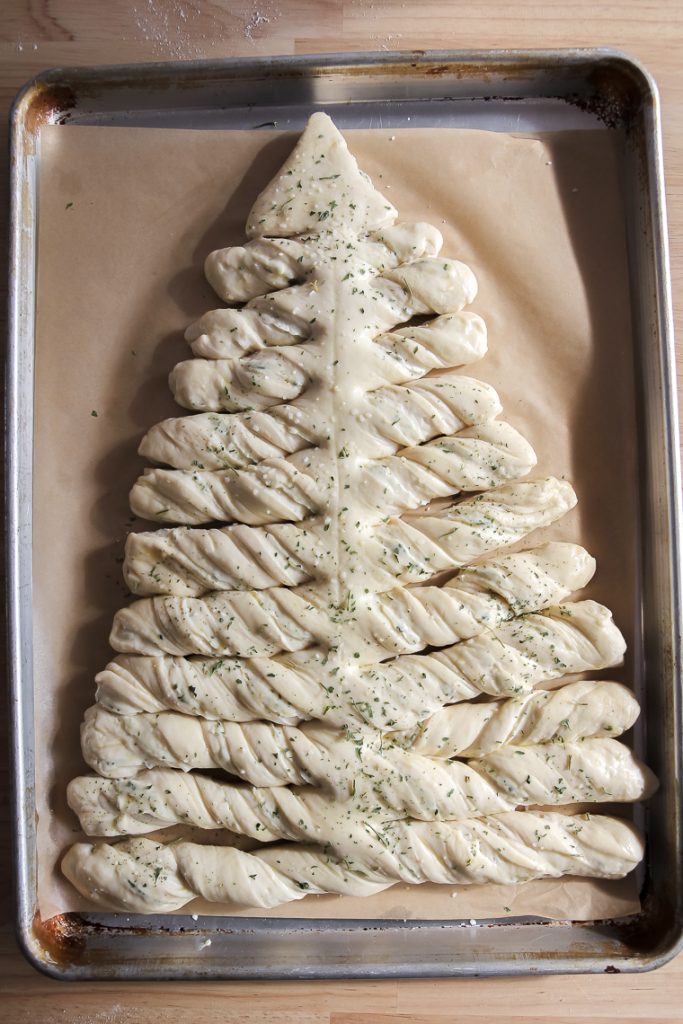Sourdough Christmas tree after proofing, brushing with egg wash, and sprinkling with parsley and salt