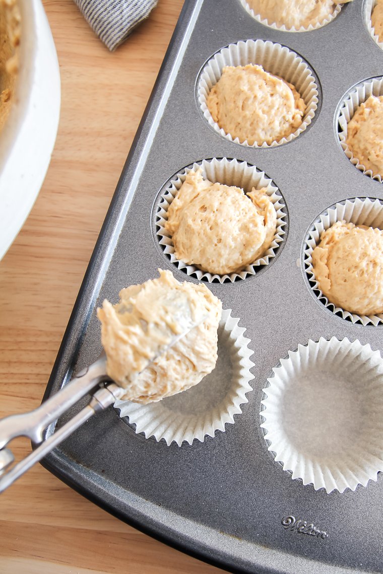 scooping the einkorn muffin batter into the prepared pan