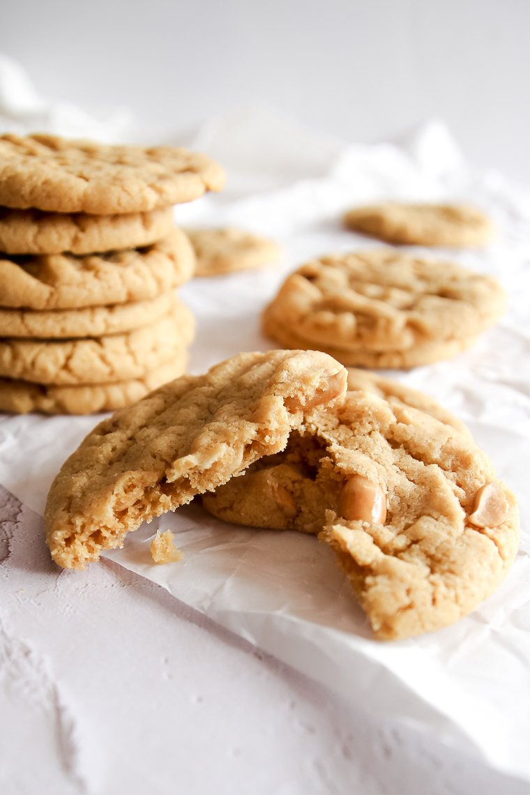 a peanut butter cookie with whole wheat flour broken in half to expose the chopped peanuts
