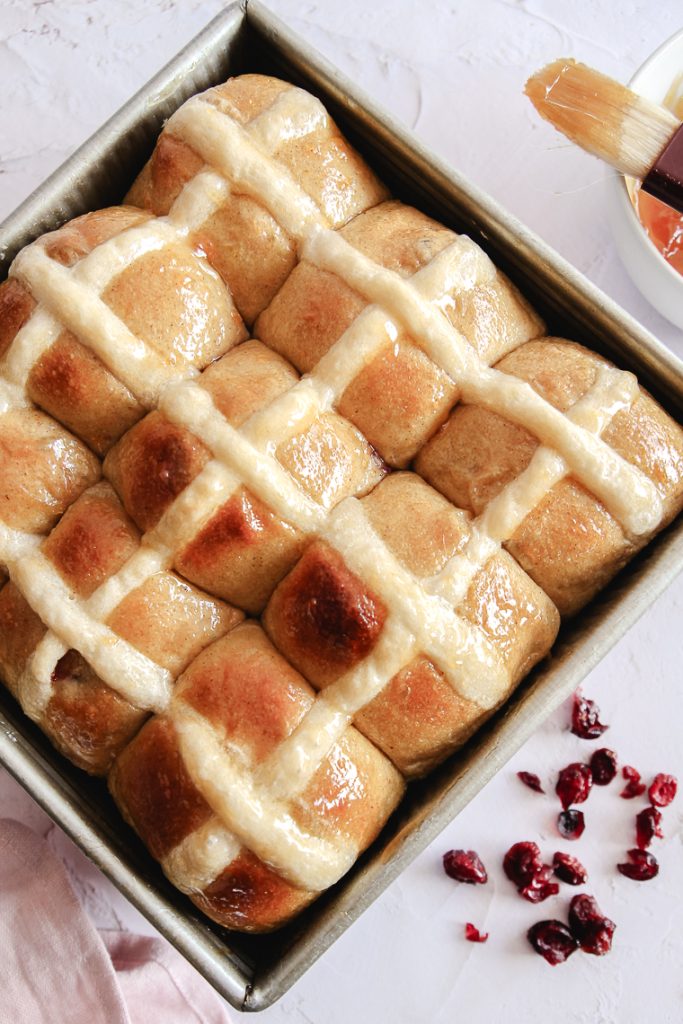 a tray of tangzhong sourdough hot cross buns with dried cranberries