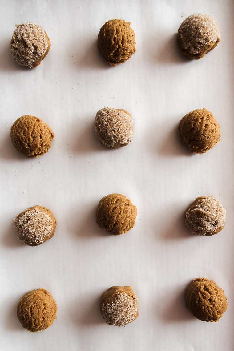 scooping out dough balls and rolling the tops in sugar