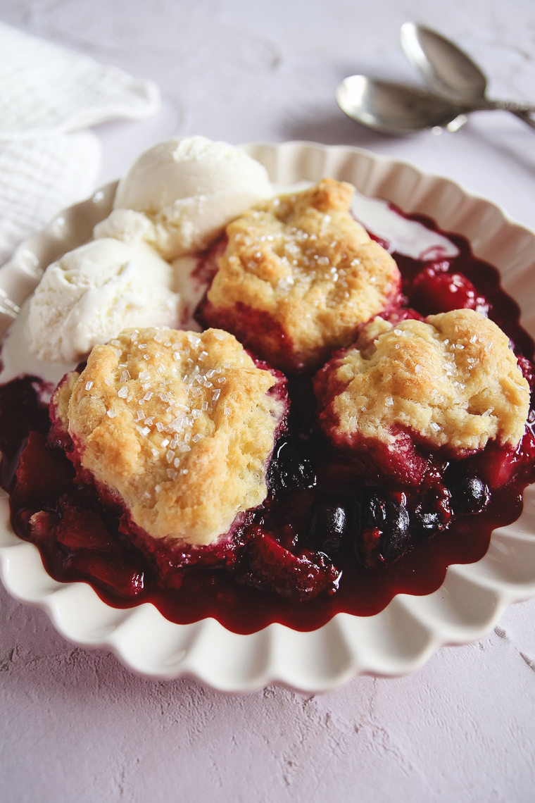 sourdough berry cobbler and ice cream on a scalloped plate