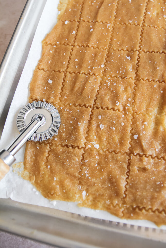cut partially-baked crackers, dock with a fork, and sprinkle with coarse salt